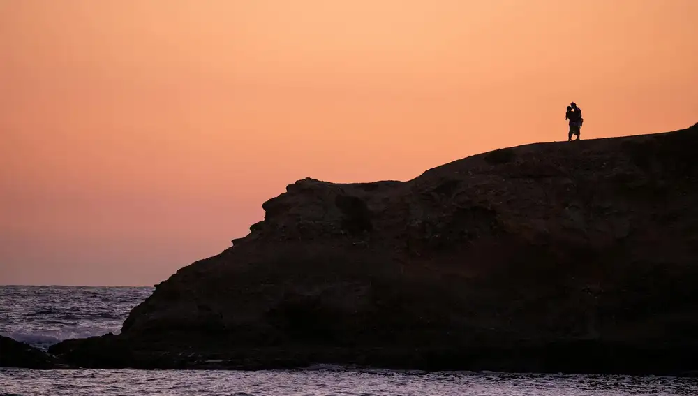 Pareja al atardecer en la costa