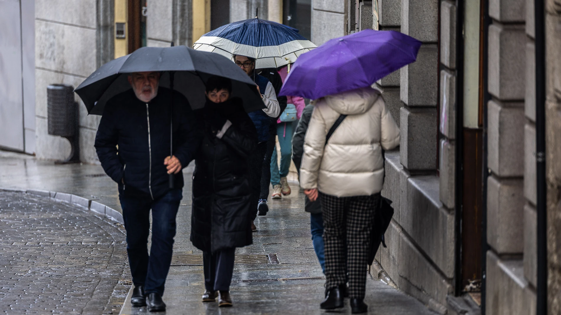 TOLEDO, 17/03/2025.- Un grupo de personas camina bajo la lluvia este lunes, en Toledo. EFE/Ismael Herrero