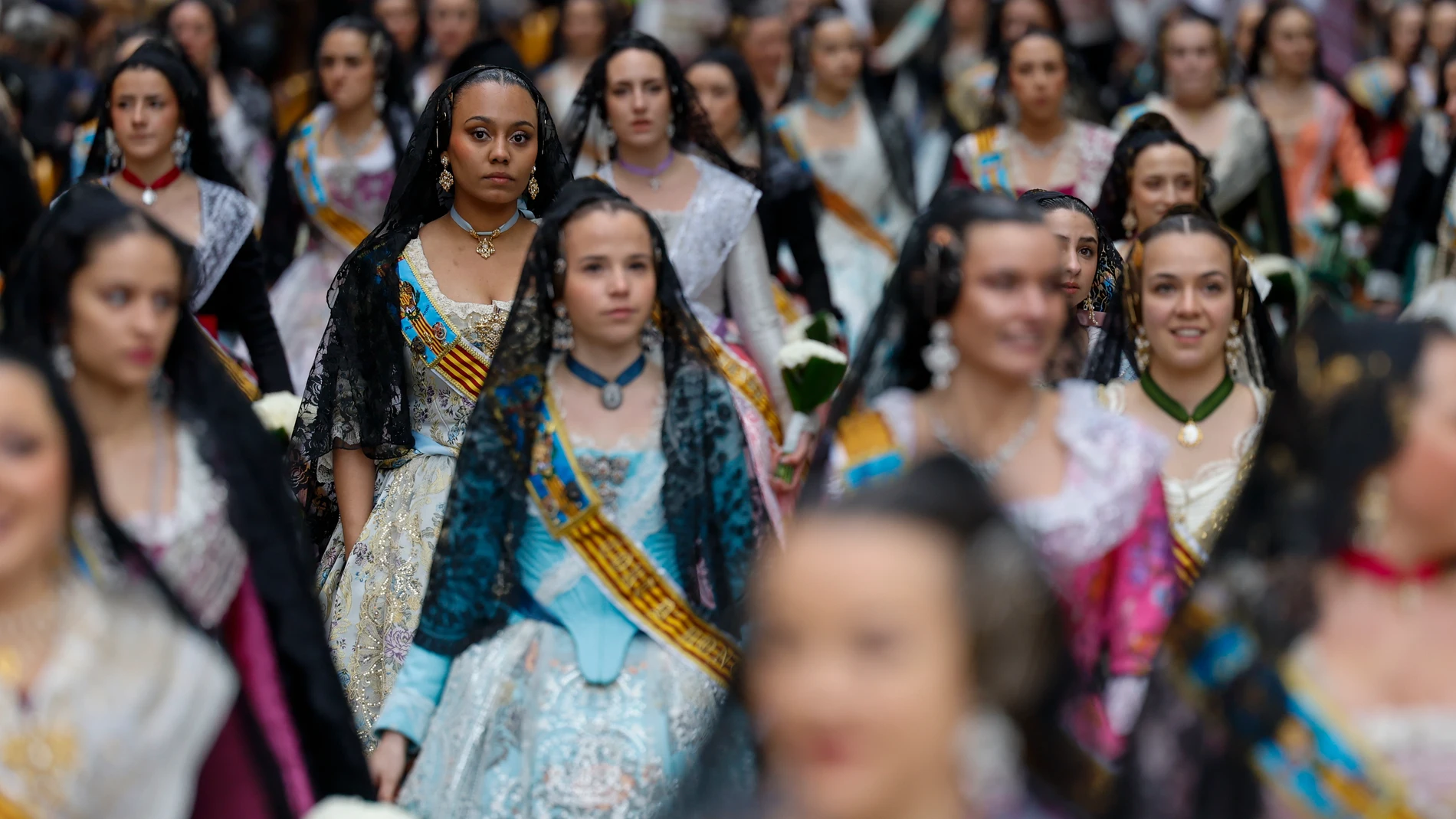 GRAFCVA6426. VALENCIA, 17/03/2025.- Numerosas falleras desfilan durante la Ofrenda de flores a la Virgen de los Desamparados, el acto más multitudinario y emotivo de las Fallas de Valencia, que celebra este lunes la primera de sus dos maratonianas jornadas de desfile devoto ante la patrona con la participación de comisiones venidas desde pueblos asolados por la dana, la previsión de marcar un nuevo récord de participación y bajo la amenaza de lluvia. EFE/Ana Escobar