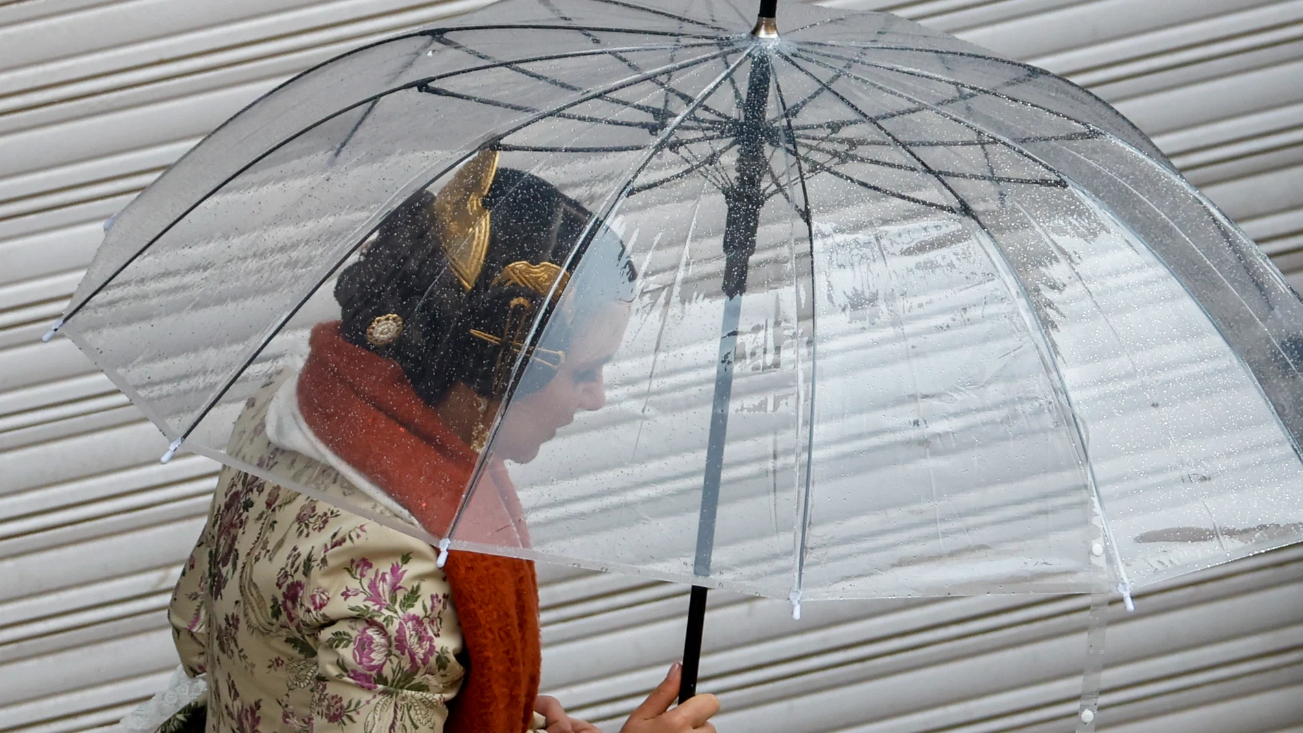FOTODELDÍA GRAFCVA6458. VALENCIA, 18/03/2025.- Una fallera se protege de la lluvia con un paraguas durante este martes en el que la inestabilidad meteorológica marca el penúltimo de las Fallas. EFE/Ana Escobar