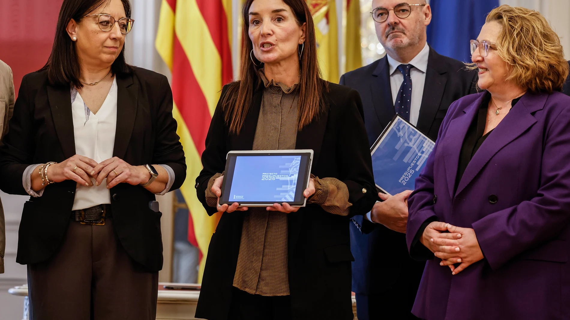 La presidenta de Les Corts de Valencia, Llanos Massó (i), recibe de la consellera de Hacienda y Economía, Ruth Merino (c), el proyecto de Ley de Presupuestos 2025, en Les Corts, a 20 de marzo de 2025, en Valencia, Comunidad Valenciana (España). Merino ha destacado que los presupuestos de la Generalitat de 2025 "recogerán las necesidades de los valencianos en sus servicios esenciales como sanidad, educación y servicios sociales’’. 20 MARZO 2025;ECONOMIA;RUTH MERINO;PRESUPUESTOS;LES CORTS Rob...