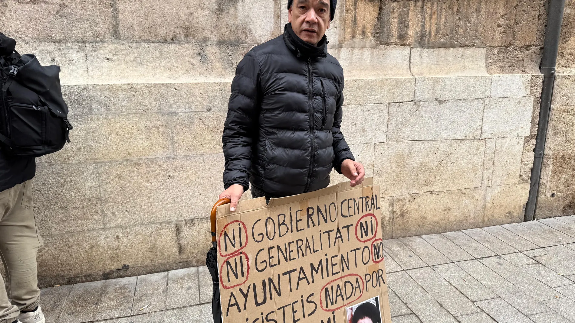 Juan José Monrabal posa con la pancarta con la cara de su madre frente al Palau de la Generalitat