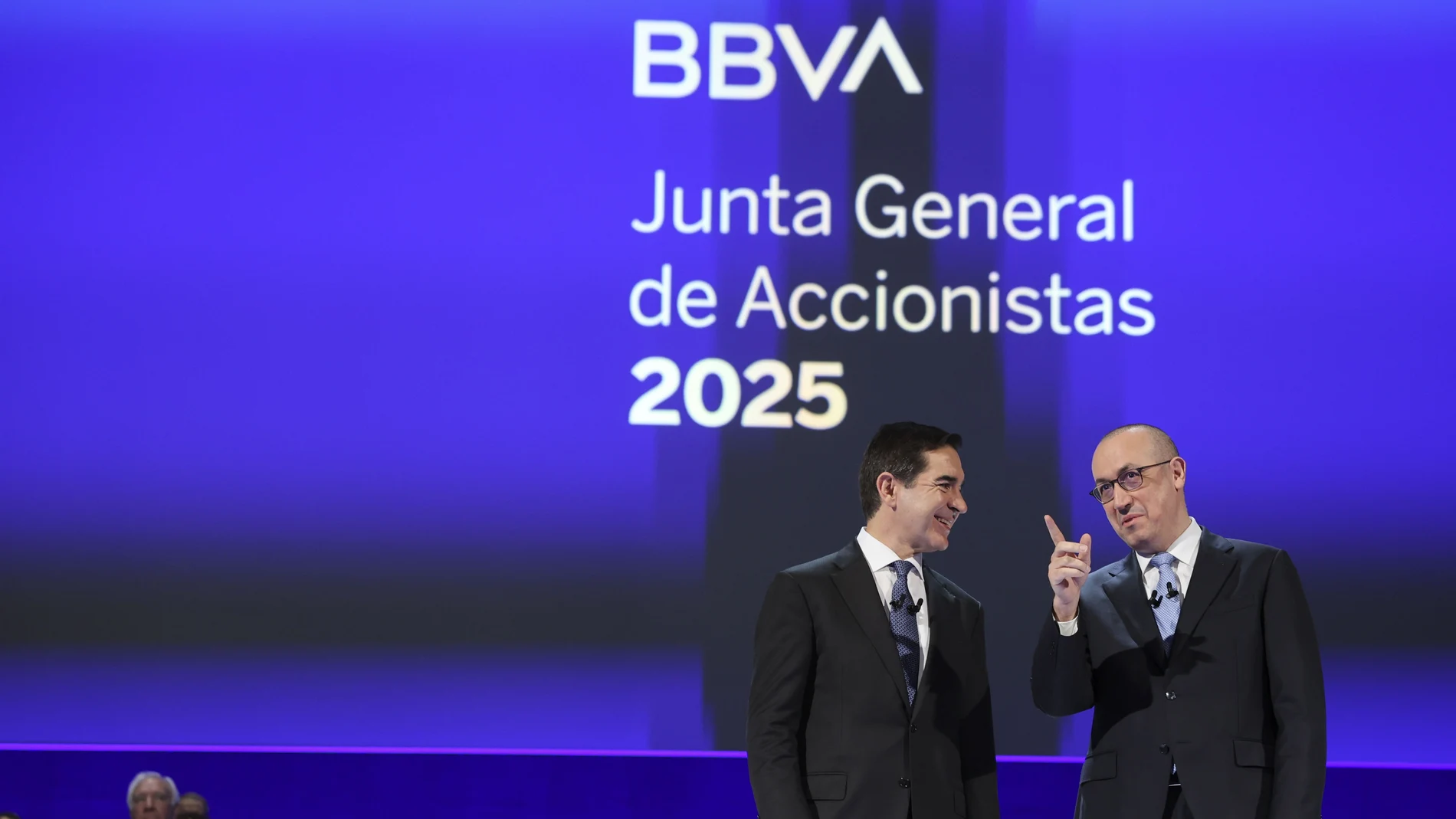 El presidente del BBVA, Carlos Torres Vila, (i) junto al director ejecutivo Onur Genç (d) en la junta donde han afirmado este viernes que la opa de su banco sobre el Sabadell es una "apuesta por España y sus empresas, por crecer y contribuir al crecimiento del país y sus territorios".