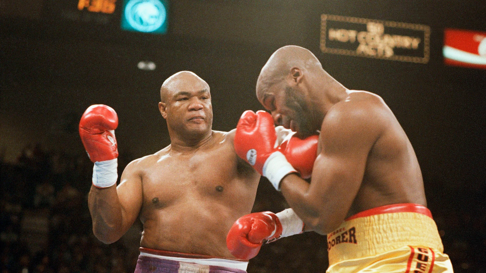 FILE - George Foreman, left, hits Michael Moorer in the face with a left during the second round of their heavyweight championship fight at the MGM Grand in Las Vegas on Saturday, Nov. 5, 1994. (AP Photo/Lennox McLendon, File)