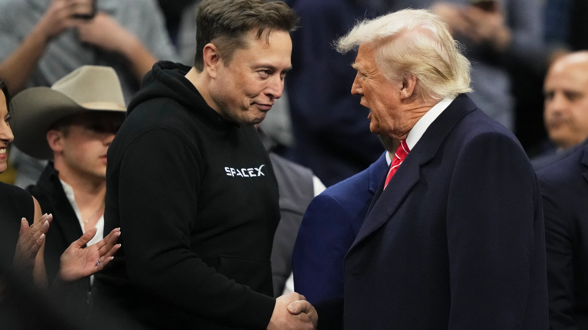 Elon Musk, left, shakes hands with President Donald Trump at the finals for the NCAA wrestling championship, Saturday, March 22, 2025, in Philadelphia. (AP Photo/Matt Rourke)