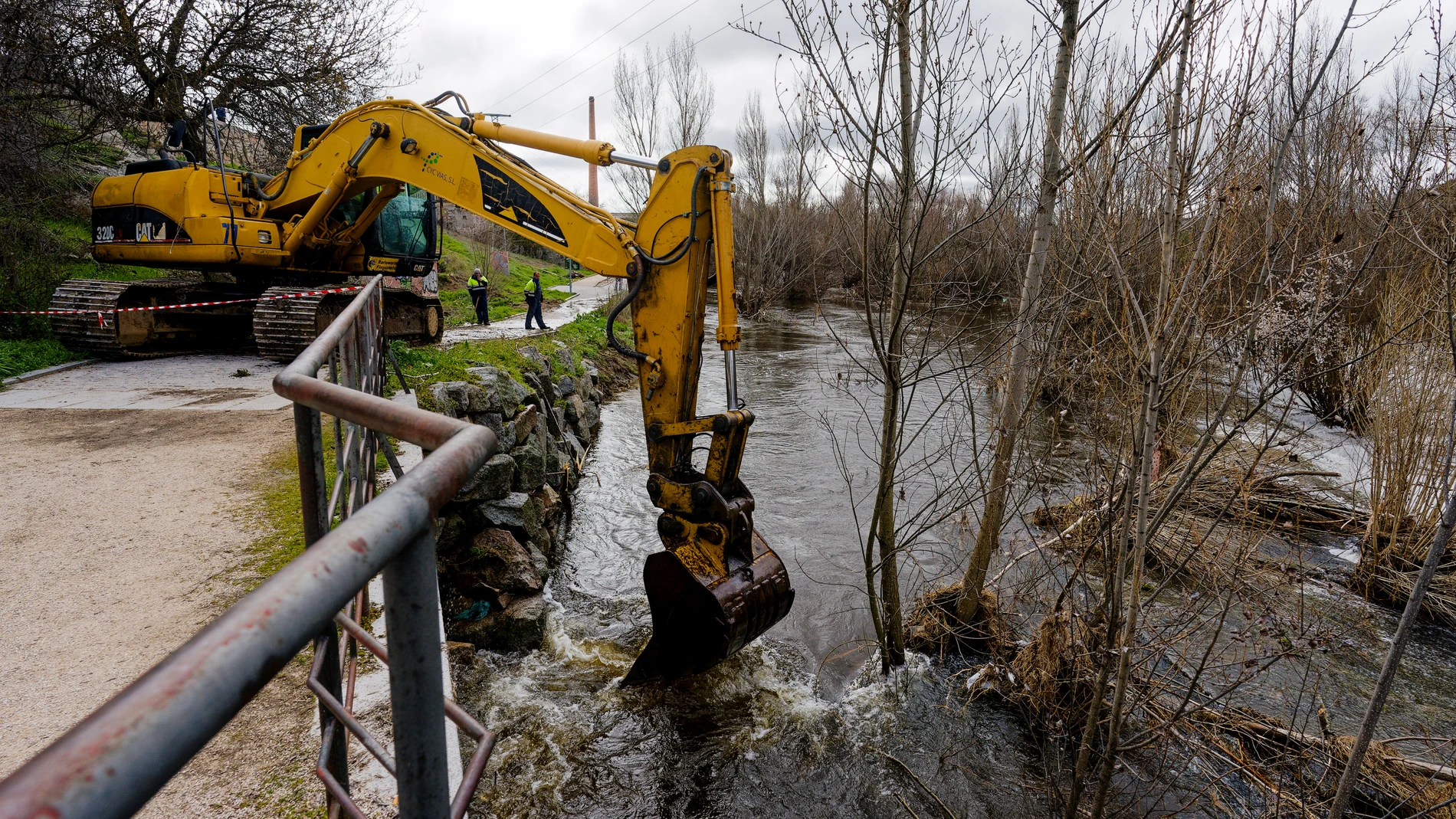 ÁVILA, 24/03/2025.- Una máquina retroexcavadora trabaja en el derribo del azud del río Adaja, a su paso por Ávila, y en labores de limpieza del cauce, este lunes. El río Adaja a su paso por Valdestillas, en Valladolid, continúa en aviso rojo, el nivel de alerta más elevado, y son un total de 21 los tramos de la cuenca del Duero que se encuentran con aviso hidrológico activo: seis de ellos en naranja, en los ríos Adaja, Duero y Eresma. EFE/ Raúl Sanchidrián
