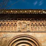 Friso sobre el pórtico románico de la iglesia de San Juan Bautista de Moarves de Ojeda, con el Pantrocrátor o representación de Dios bendiciendo y sujetando los evangeliso en el centro rodeado de los apóstoles