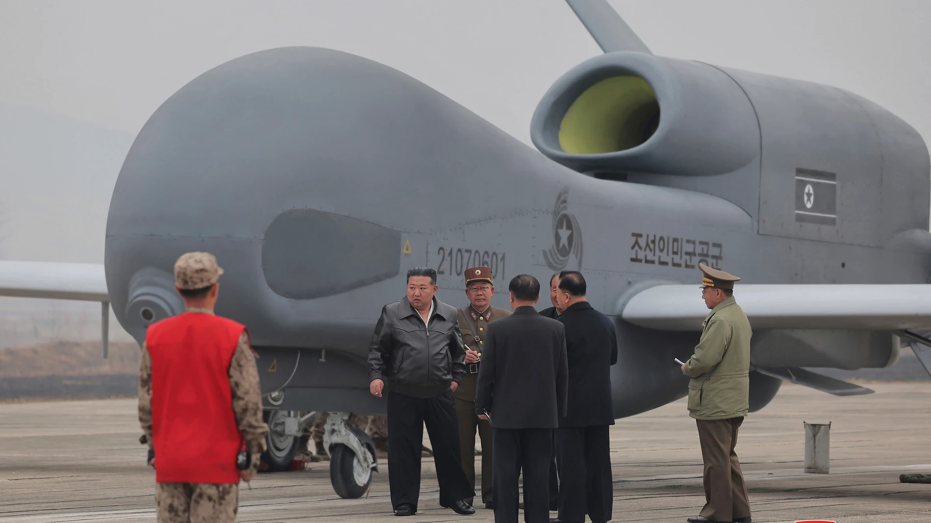 In this photo provided Thursday, March 27, 2025, by the North Korean government, its leader Kim Jong Un, center left in a black jacket, stands by what appeared to be a large reconnaissance drone at an undisclosed location in North Korea, earlier this week. Independent journalists were not given access to cover the event depicted in this image distributed by the North Korean government. The content of this image is as provided and cannot be independently verified. Korean language watermark on ...