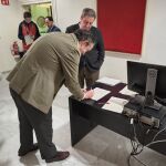 Los portavoces del PP y vox en la Comisión de Investigación de la Dana, Nando Pastor y José María Llanos, firman el documento antes de entregarlo en el registro de Les Corts