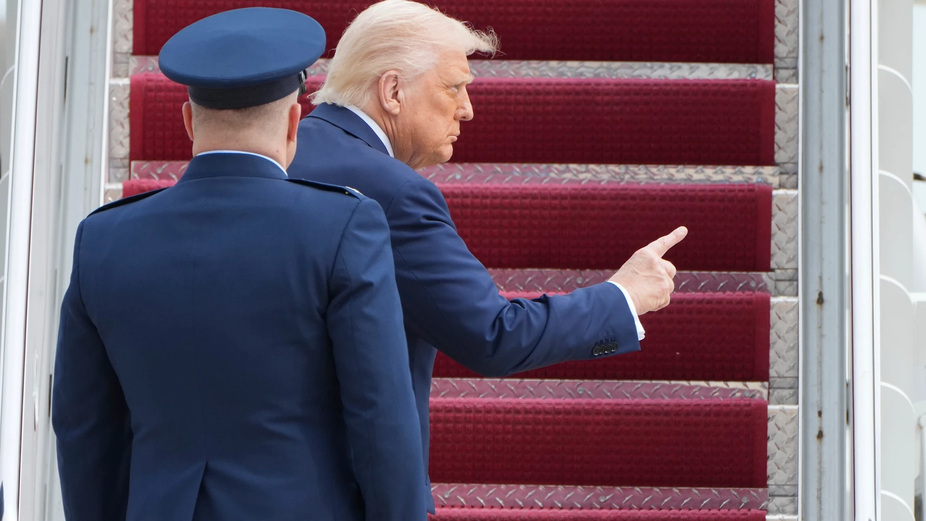 President Donald Trump gestures as he walks with Col. Paul Pawluk, Vice Commander of the 89th Airlift Wing, left, to board Air Force One at Joint Base Andrews, Md., Friday, March 28, 2025, en route to Florida for the weekend. (AP Photo/Jacquelyn Martin)