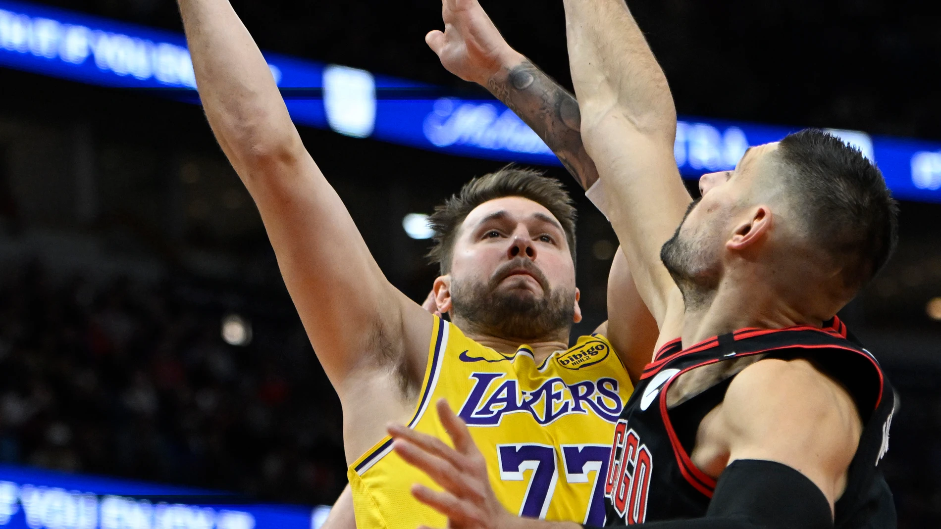 Los Angeles Lakers' Luka Doncic (77) goes up for a shot against Chicago Bulls' Nikola Vucevic (9) and Kevin Huerter (13) during the first half of an NBA basketball game Thursday, March 27, 2025, in Chicago. (AP Photo/Paul Beaty)