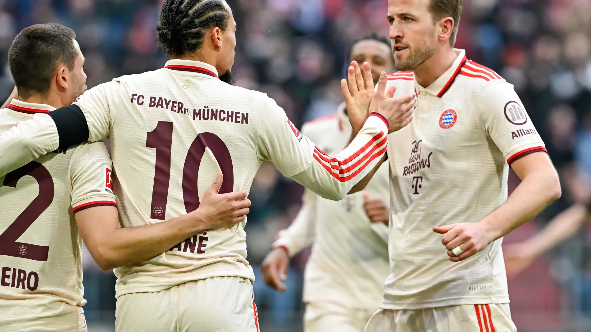 Bayern Munich's Leroy Sane, centre, and teammate Harry Kane high five as they celebrate after Sane scored their side's second goal of the game during the Bundesliga soccer match between Bayern Munich and St. Pauli, at the Allianz Arena stadium in Munich, Germany, Saturday March 29, 2025. (Peter Kneffel/dpa via AP)