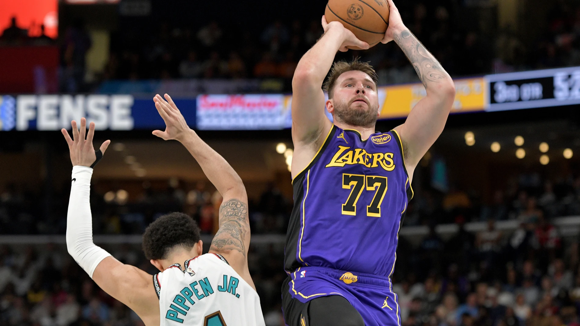 Los Angeles Lakers guard Luka Doncic (77) shoots against Memphis Grizzlies guard Scotty Pippen Jr. (1) in the second half of an NBA basketball game Saturday, March 29, 2025, in Memphis, Tenn. (AP Photo/Brandon Dill)