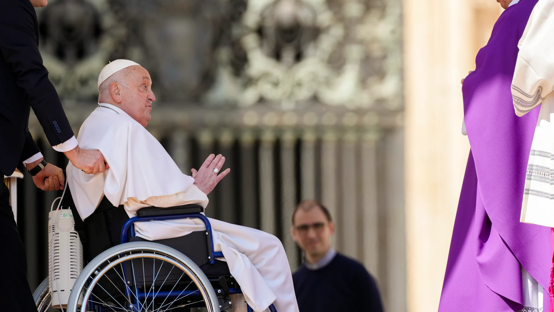 Pope Francis waves to Archbishop Salvatore Fisichella, right, as he arrives in a wheelchair at the end of a mass in St. Peter's Square at The Vatican, Sunday, April 6, 2025, part of the Jubilee of the sick and the health workers. (AP Photo/Andrew Medichini)