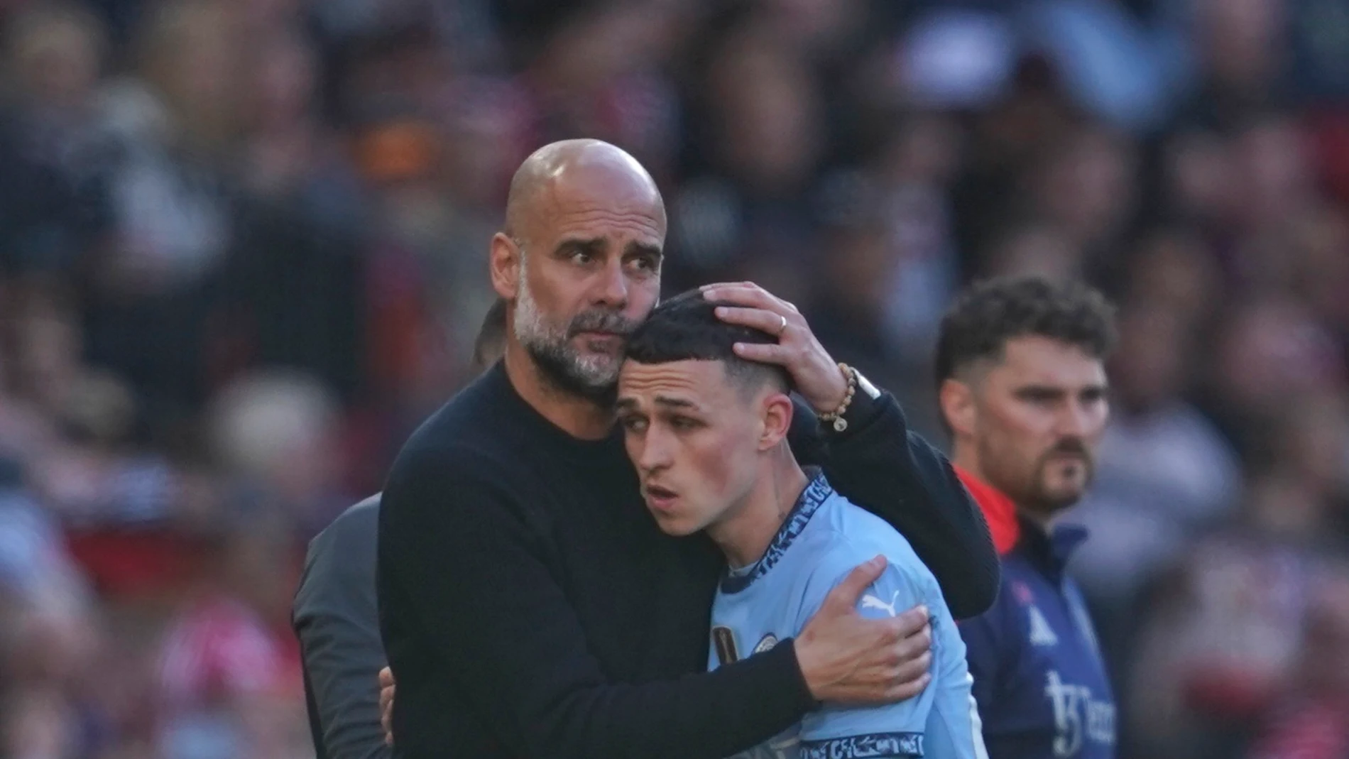 Manchester City's head coach Pep Guardiola hugs Phil Foden as he is substituted during the English Premier League soccer match between Manchester City and Manchester United in Manchester, England, Sunday, April 6, 2025. (AP Photo/Dave Thompson)