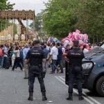 Dos agentes de la Policía Nacional vigilan el paso de Palío de la Virgen María Santísima del Refugio de la Hermandad de San Bernardo a su salida de este popular barrio sevillano.