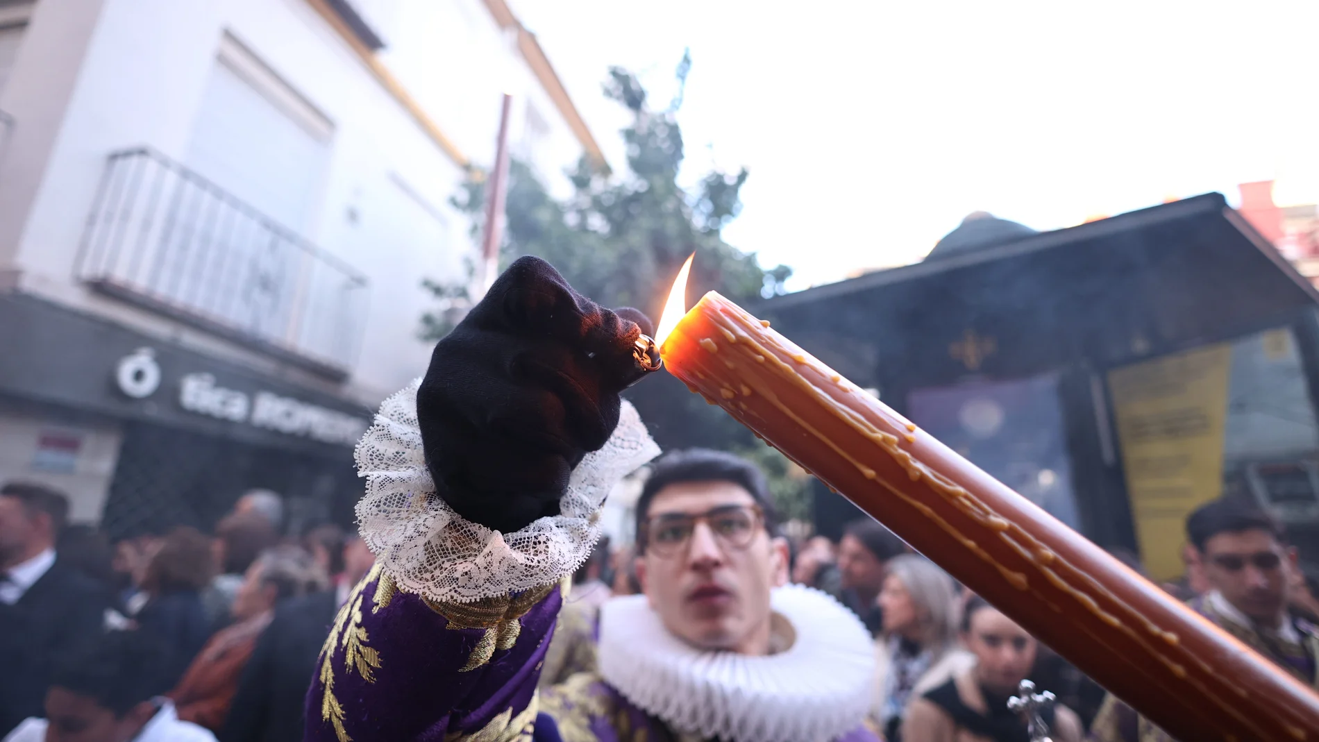 Un acolito del El cristo de los Javieres enciende un cirio