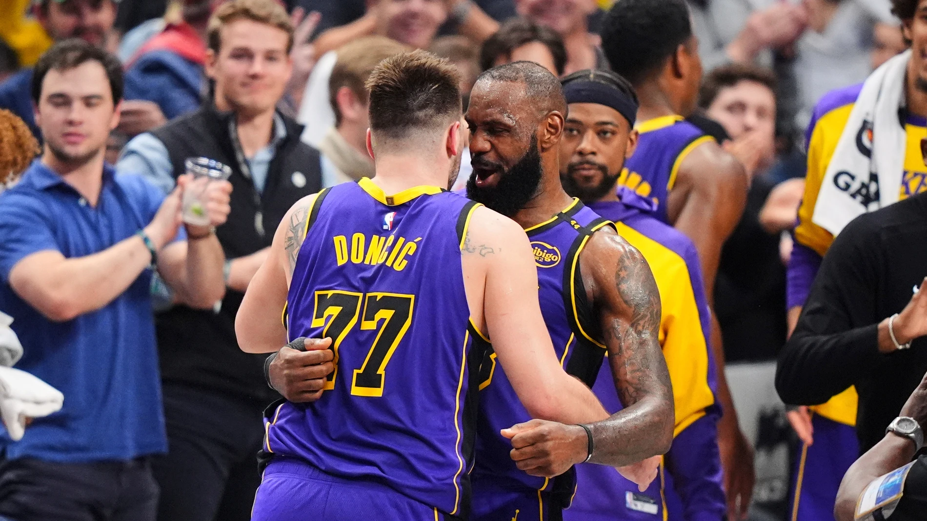 Los Angeles Lakers' Luka Doncic (77) and LeBron James, center, right, hug and celebrate late in the second half of an NBA basketball game against the Dallas Mavericks in Dallas, Wednesday, April 9, 2025. (AP Photo/LM Otero)