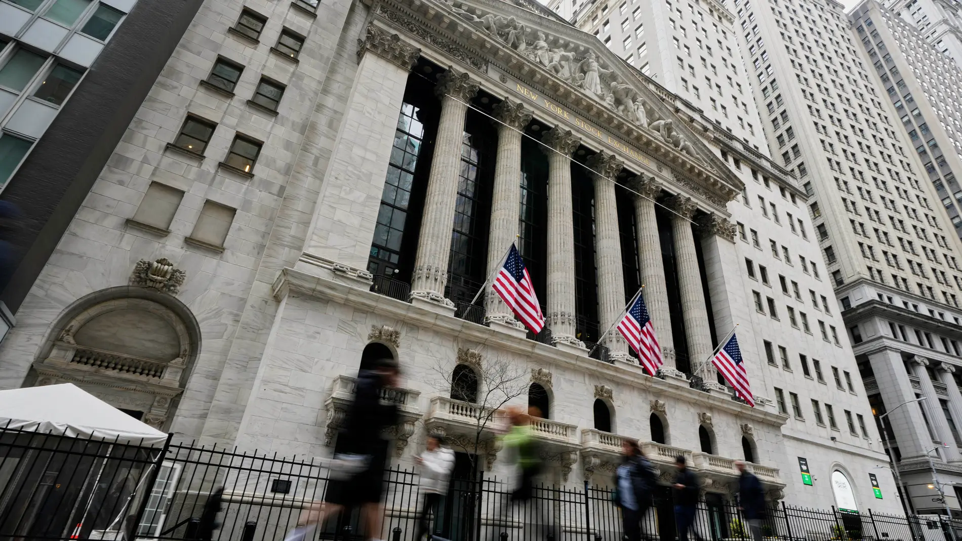 People walk by the New York Stock Exchange, Thursday morning, April 10, 2025. (AP Photo/Richard Drew)
