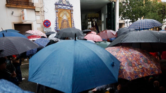  Una multitud se protege de la lluvia con paraguas a las puertas de la Cofrad&iacute;a de Nuestro Se&ntilde;or Cautivo y la virgen de La Trinidad