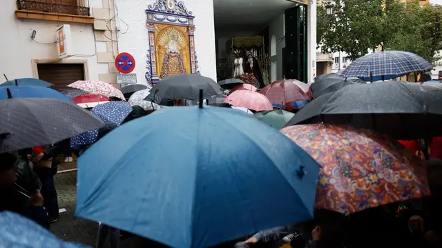 Una multitud se protege de la lluvia con paraguas a las puertas de la Cofradía de Nuestro Señor Cautivo y la virgen de La Trinidad Una multitud se protege de la lluvia con paraguas a las puertas de la Cofradía de Nuestro Señor Cautivo y la virgen de La Trinidad