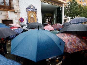  Una multitud se protege de la lluvia con paraguas a las puertas de la Cofrad&iacute;a de Nuestro Se&ntilde;or Cautivo y la virgen de La Trinidad