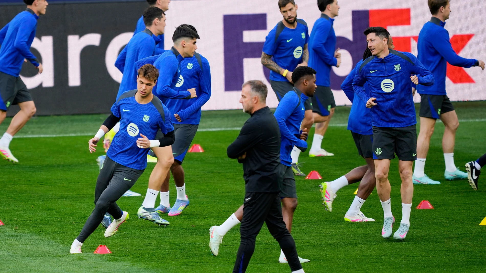 Barcelona's Robert Lewandowski, right, exercises behind Barcelona's head coach Hansi Flick, center, during a training session in the Dortmund stadium ahead of the Champions League quarterfinal second leg soccer match between Borussia Dortmund and FC Barcelona, in Dortmund, Germany, Monday, April 14, 2025. (AP Photo/Martin Meissner)