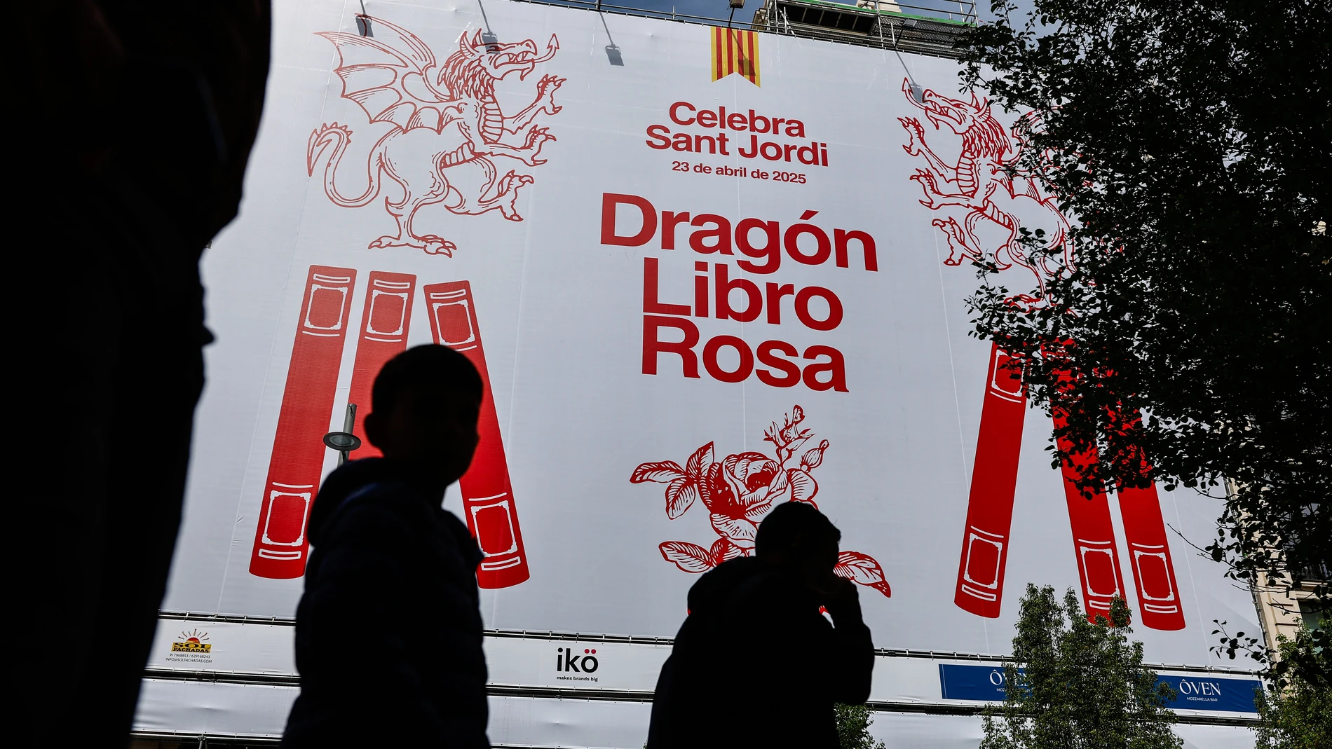 MADRID, 15/04/2025.- La Gran Vía madrileña luce desde el mediodía de este martes una lona gigante que promociona las actividades culturales de Sant Jordi en la ciudad, una de las iniciativas de la Generalitat con el fin de "fortalecer los vínculos entre Cataluña y Madrid". Así lo ha trasladado el Govern a los periodistas, junto a una imagen de dicha lona en la que se puede leer "Drac Llibre Rosa" en catalán y "Dragón Libro Rosa", en castellano. EFE/ Rodrigo Jiménez