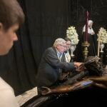 Ramón Gómez con su nieta y su nieto elaboran la corona del Cristo de Mena de Málaga