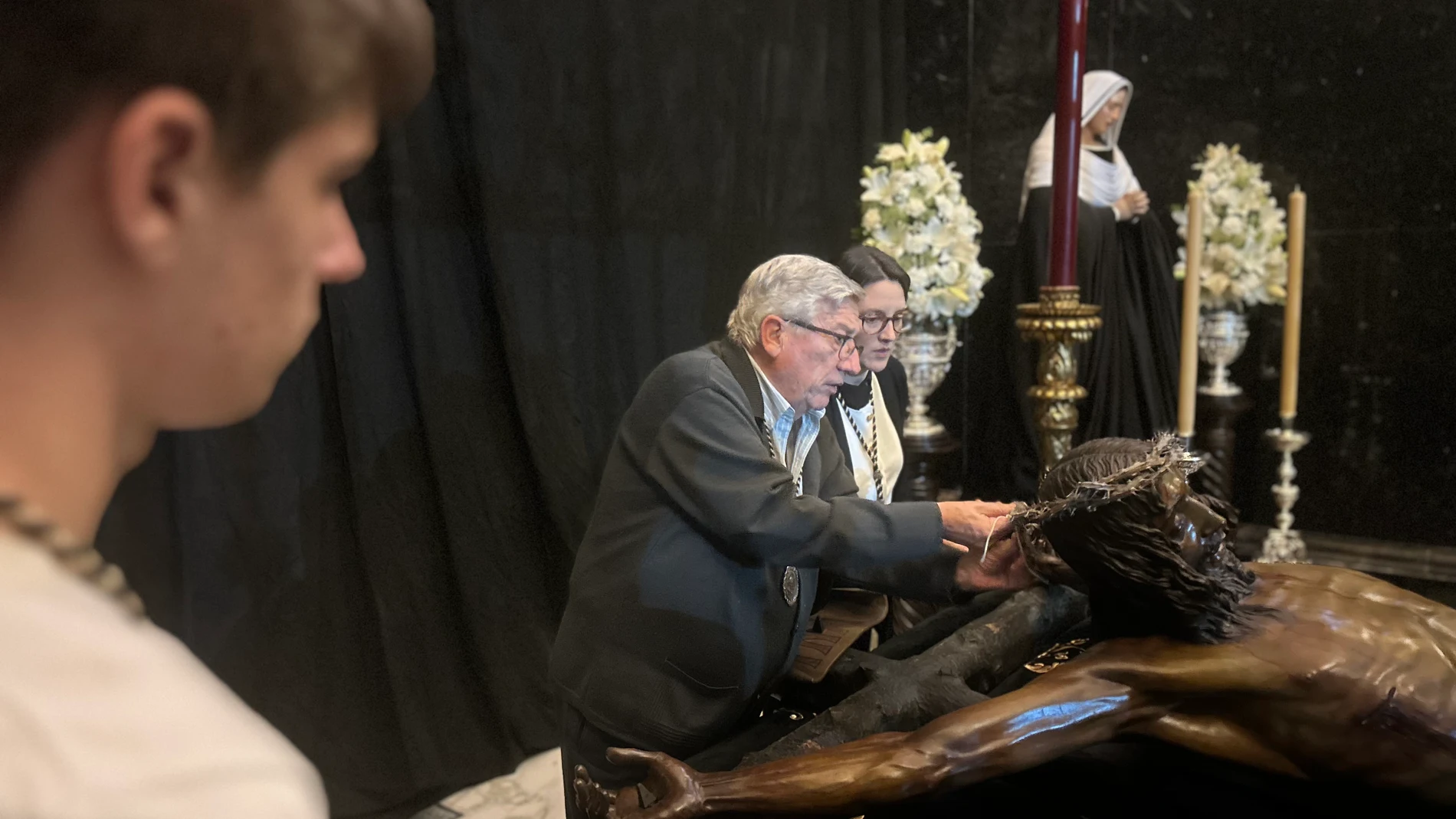 Ramón Gómez con su nieta y su nieto elaboran la corona del Cristo de Mena de Málaga
