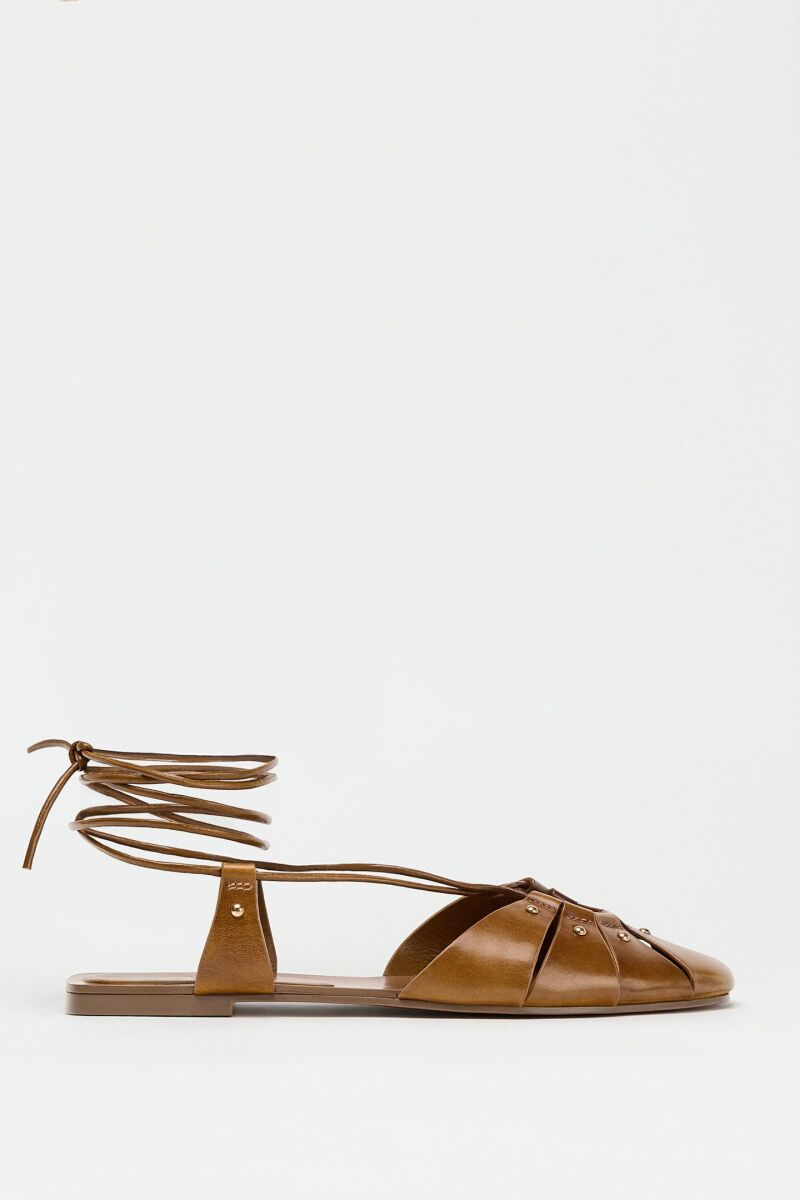 Sandalias planas atadas.