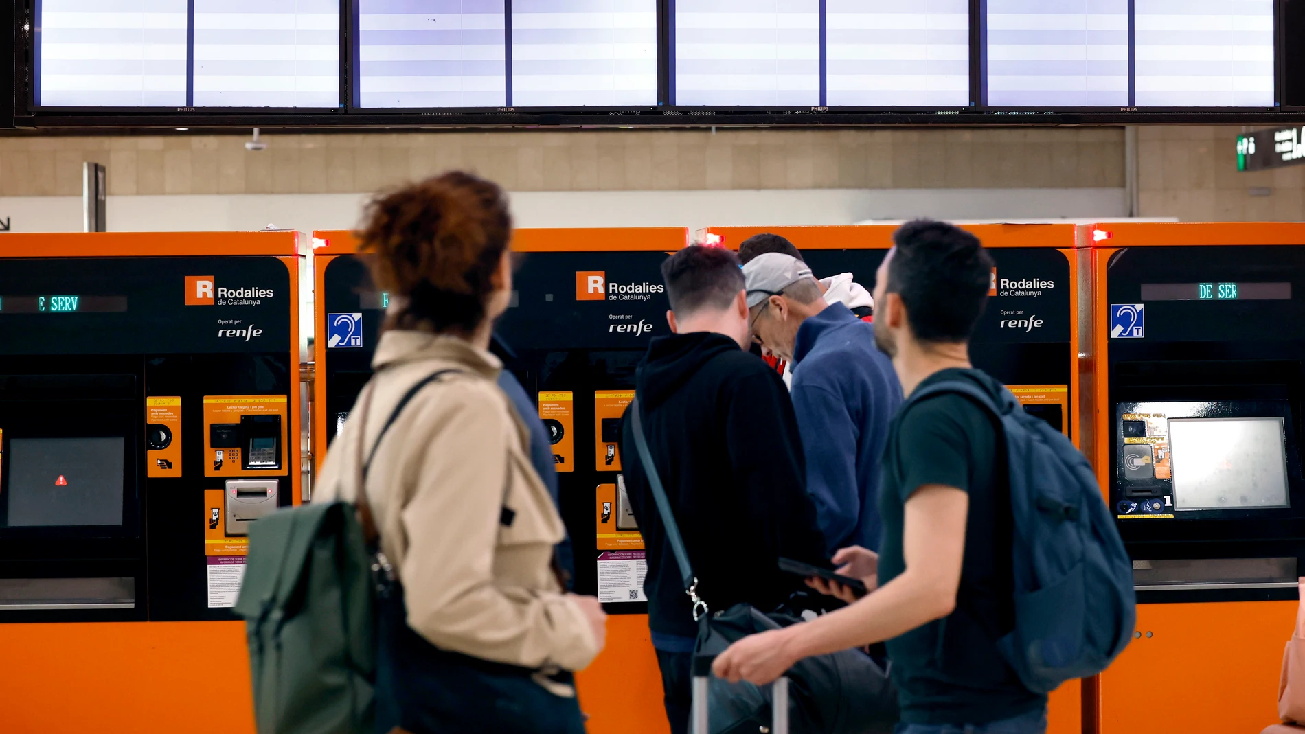 GRAFCAT7671. BARCELONA, 29/04/2025.- Varias personas ante las taquillas y los paneles informativos de Rodalies que aparecen en blanco en la Estación de Sants después de que Renfe haya anunciado que servicio ferroviario de Rodalies en Cataluña se encuentra suspendido debido a la inestabilidad de la tensión en la red eléctrica para garantizar la circulación de los trenes. EFE/Toni Albir