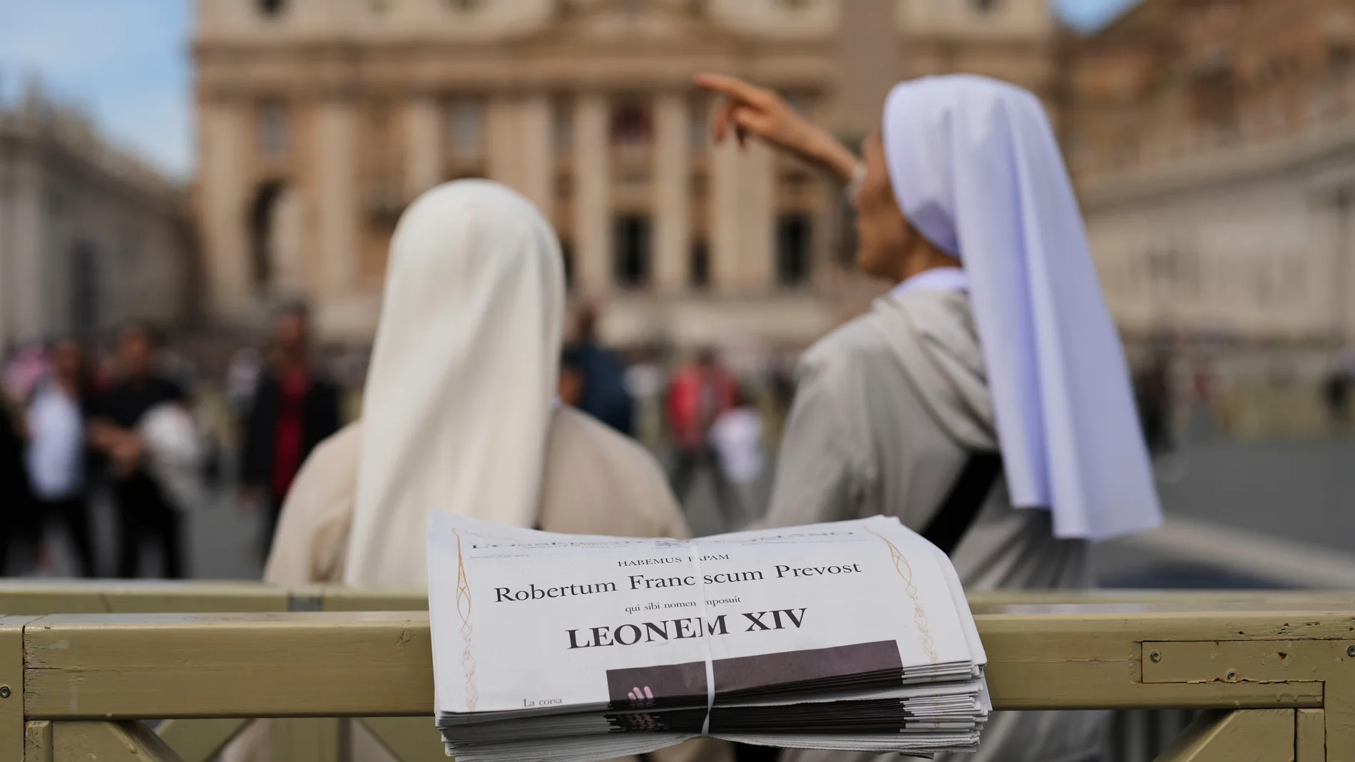 Religiosas frente a la portada de un periódico italiano con la noticia del nuevo Papa en portada