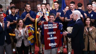 VALENCIA, 26/05/2025.- El president de la Generalitat, Carlos Maz&oacute;n, muestra la camiseta conmemorativa que le ha entregado el presidente del Levante UD, Pablo S&aacute;nchez (dcha), durante la recepci&oacute;n a la plantilla y el cuerpo t&eacute;cnico y directivo del equipo ascendido a Primera Divisi&oacute;n tras la pen&uacute;ltima jornada de Segunda Divisi&oacute;n. EFE/Biel Ali&ntilde;o 