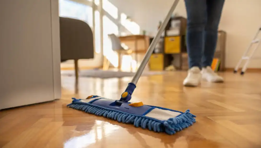 Una empleada del hogar limpia una casa