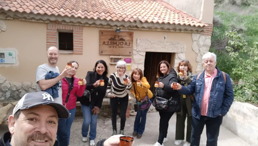 Un grupo de visitantes brinda con el jarrillo típico de vino de la zona junto a Silvia Camacho a las puertas de La Olmilla