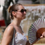 Una viandante se abanica para combatir el calor 
