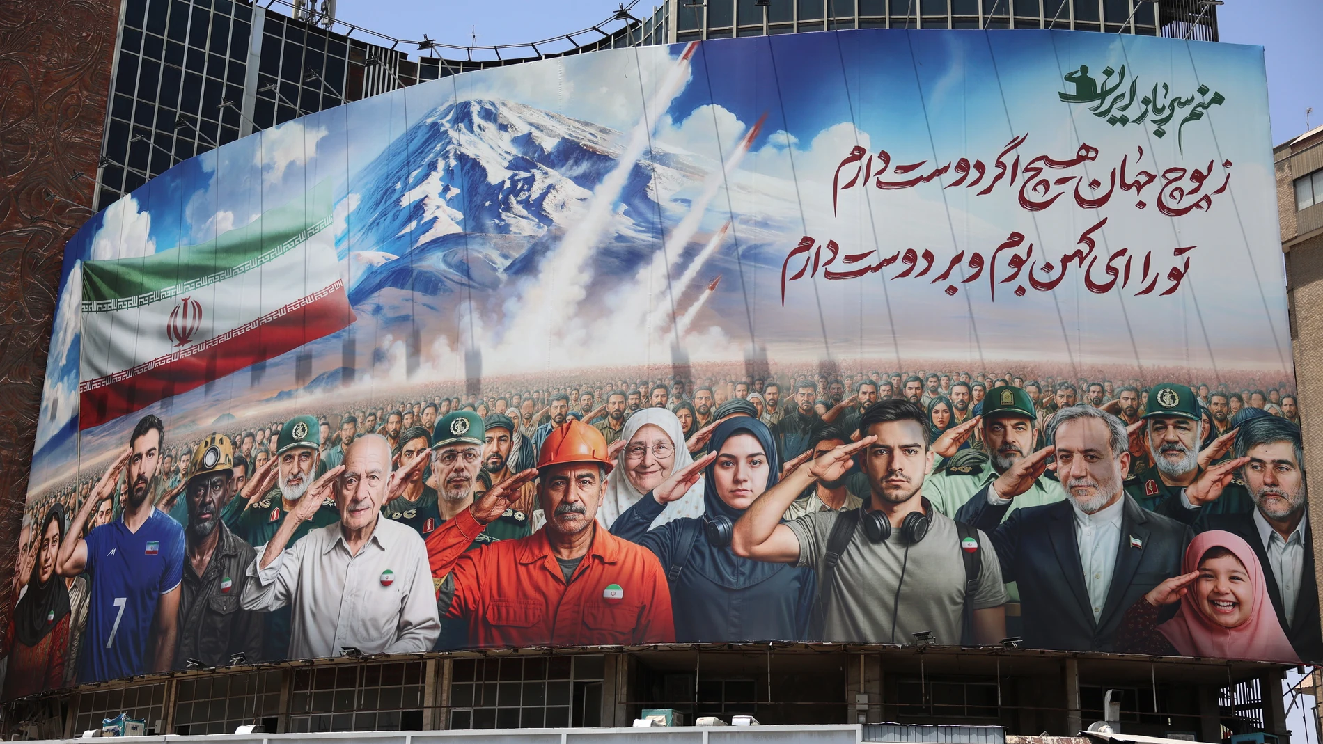 Tehran (Iran (Islamic Republic Of)), 22/06/2025.- A billboard hangs on a building depicting various Iranians including military personnel and Iranian Foreign Minister Abbas Araghchi (3-R) saluting, and a message reading 'We all are soldiers of Iran' at Vali-Asr square in Tehran, Iran, 22 June 2025. The US forces struck three of Iran's key nuclear sites: Natanz, Isfahan and Fordo, US President Trump announced on 21 June. Israel and Iran have been exchanging fire since Israel launched strikes a...