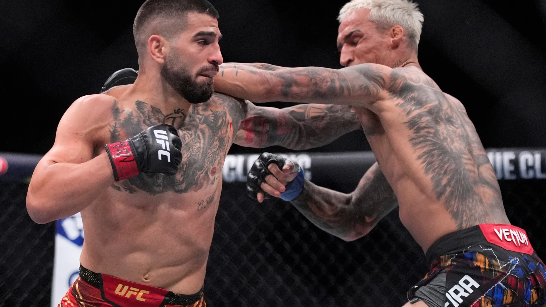 Ilia Topuria, left, hits Charles Oliveira in a lightweight title fight at UFC 317, Saturday, June 28, 2025, in Las Vegas. (AP Photo/John Locher)