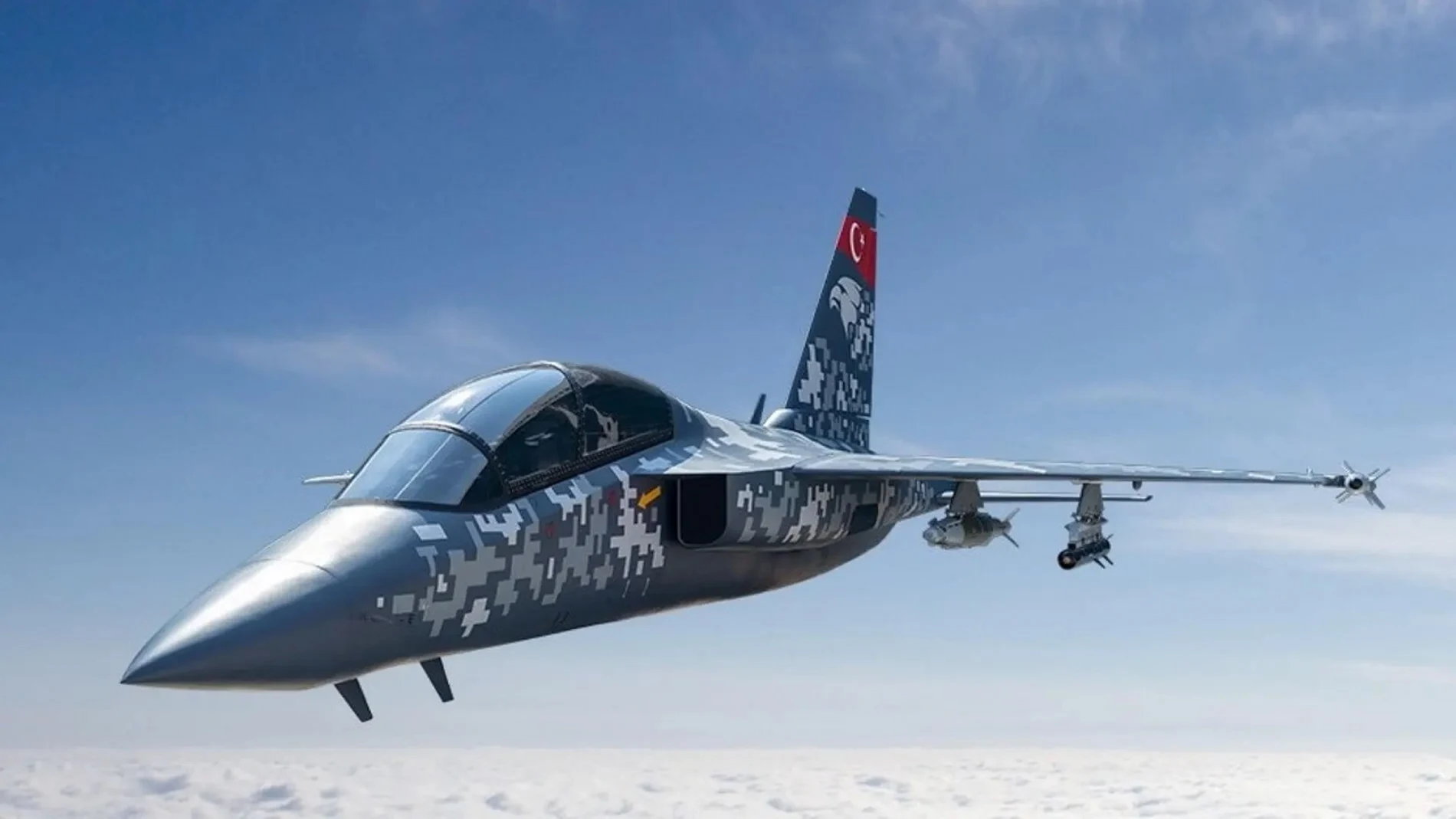Un avión con camuflaje blanco y gris y un patrón rectangular en vuelo. En el timón lleva la bandera de Turquía