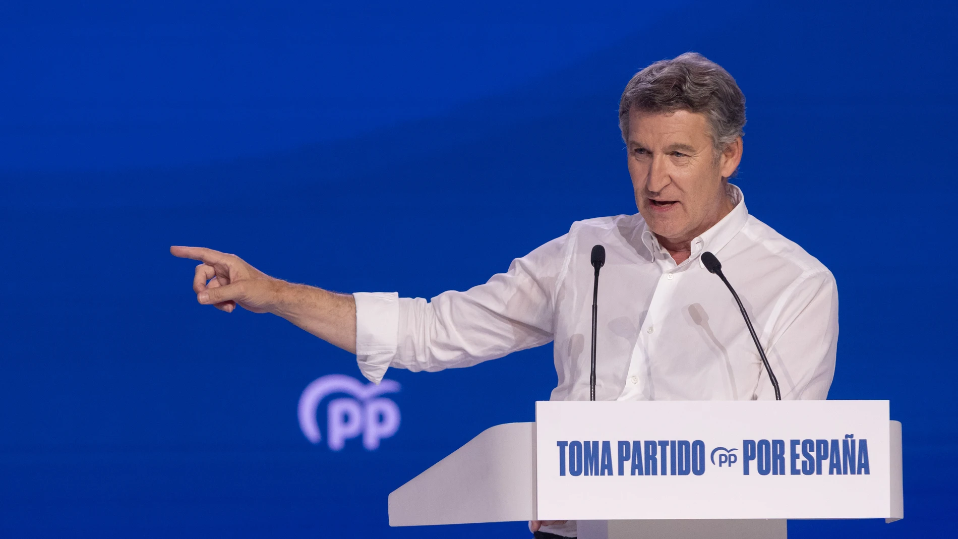 Alberto Núñez Feijóo señala ante los medios de comunicación con el brazo