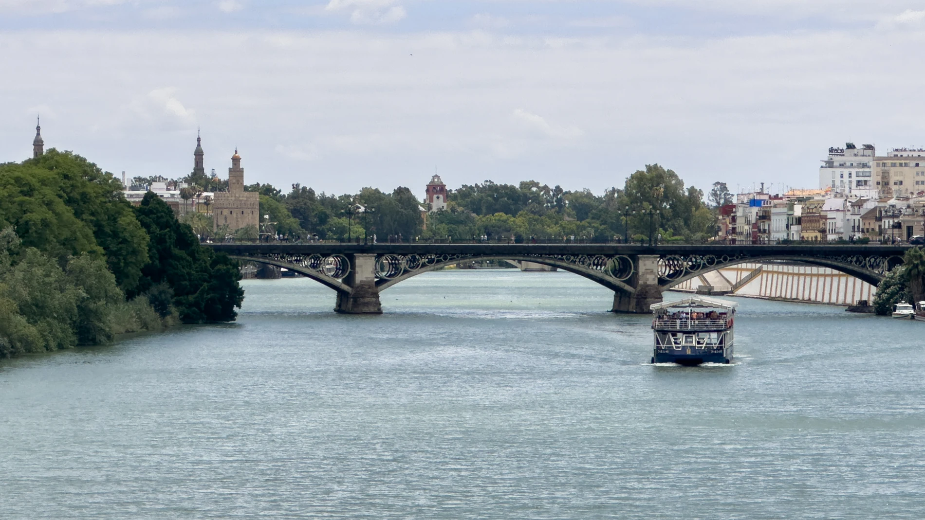 SEVILLA, 12/07/2025.- Un barco por el río Guadalquivir, este sábado en Sevilla. Los cielos estarán este sábado poco nubosos o despejados en Andalucía, donde las temperaturas descenderán ligeramente o permanecerán igual, según la previsión de la Agencia Estatal de Meteorología (Aemet). EFE/David Arjona