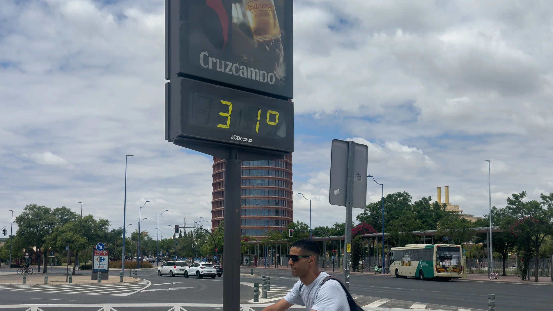 SEVILLA, 12/07/2025.- Un hombre montando en bicicleta pasa junto a un termómetro que marca 31 grados, este sábado en Sevilla. Los cielos estarán este sábado poco nubosos o despejados en Andalucía, donde las temperaturas descenderán ligeramente o permanecerán igual, según la previsión de la Agencia Estatal de Meteorología (Aemet). EFE/David Arjona