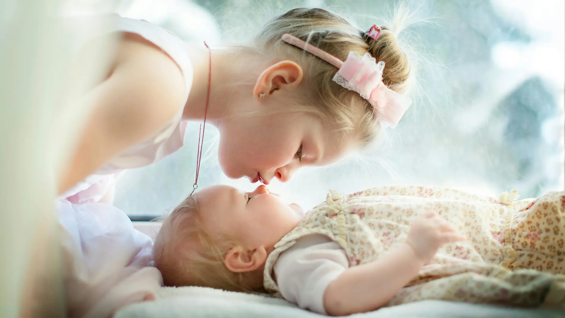 Hermana mayor da un beso a la pequeña