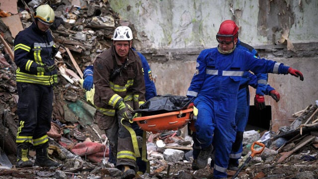 Servicios de emergencia transportando el cuerpo de los fallecidos por un ataque ruso en Kiev