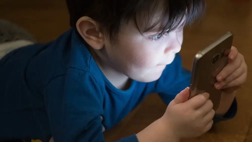 Un niño ante la pantalla de un teléfono móvil