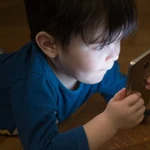 Un niño ante la pantalla de un teléfono móvil