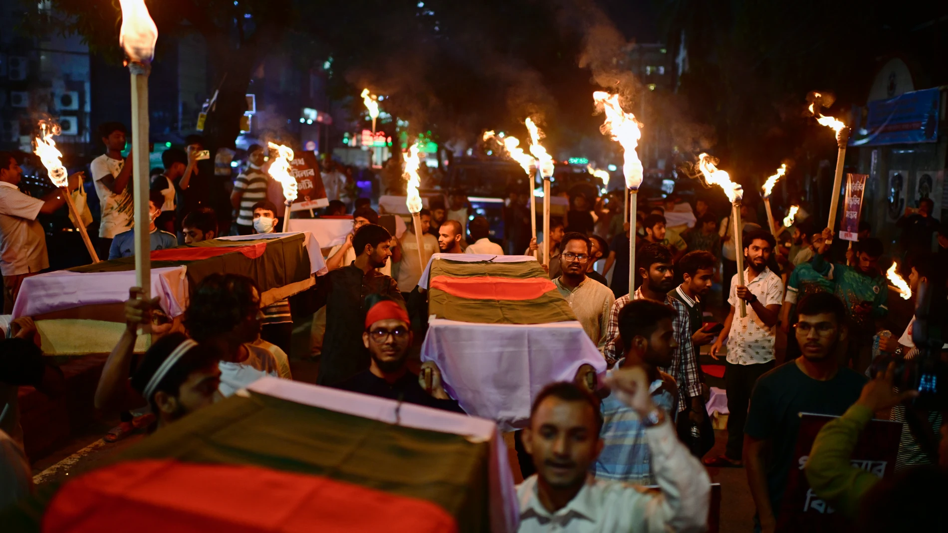 In this July 16, 2025 photo, activists carry symbolic coffins and torches during a procession to mark the day of a student-led protest one year ago, in Dhaka, Bangladesh. (AP Photo/Mahmud Hossain Opu)