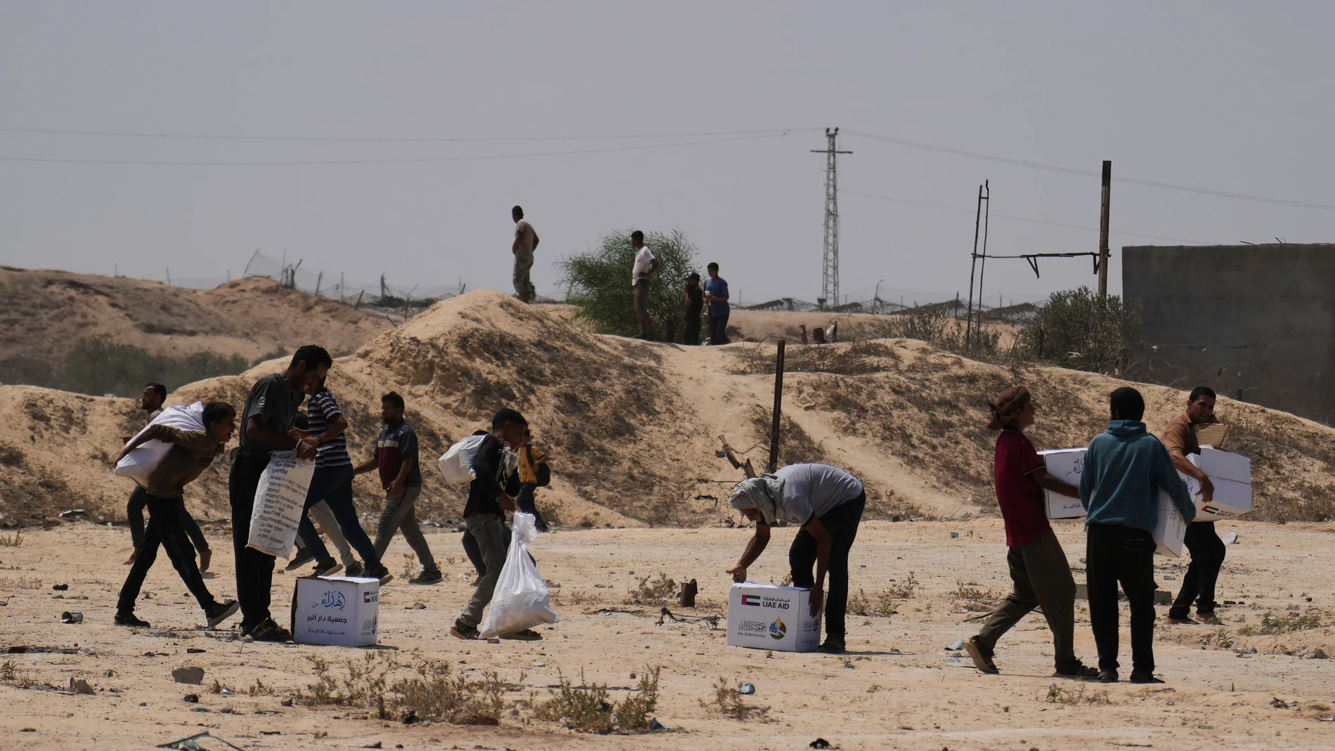 Palestinians collect humanitarian aid packages from the United Arab Emirates after they were airdropped into Deir al-Balah, in central Gaza Strip, Saturday, Aug. 9, 2025. (AP Photo/Abdel Kareem Hana)