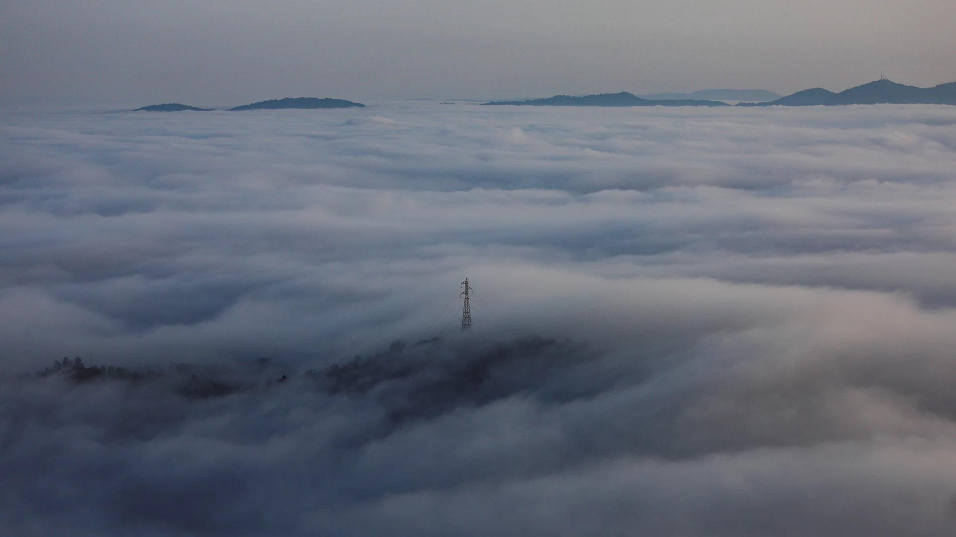 VIGO (PONTEVEDRA), 11/08/2025.- Un mar de nubes cubre la ciudad de Vigo en el amanecer de este lunes visto desde el monte Alba. EFE/sxenick